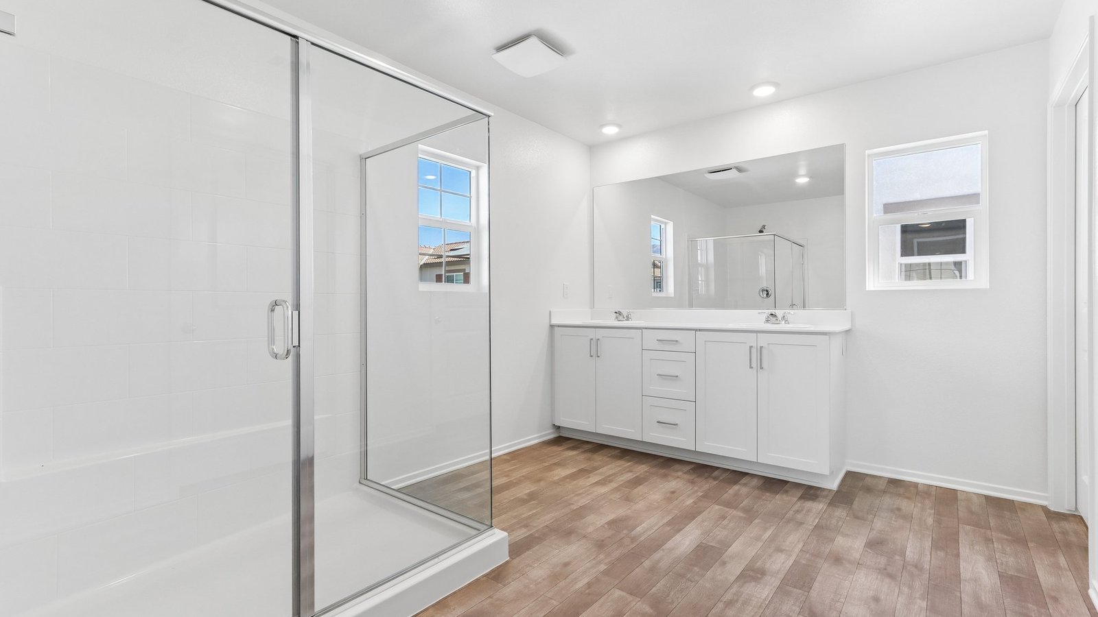 primary bathroom with dual vanity and shower