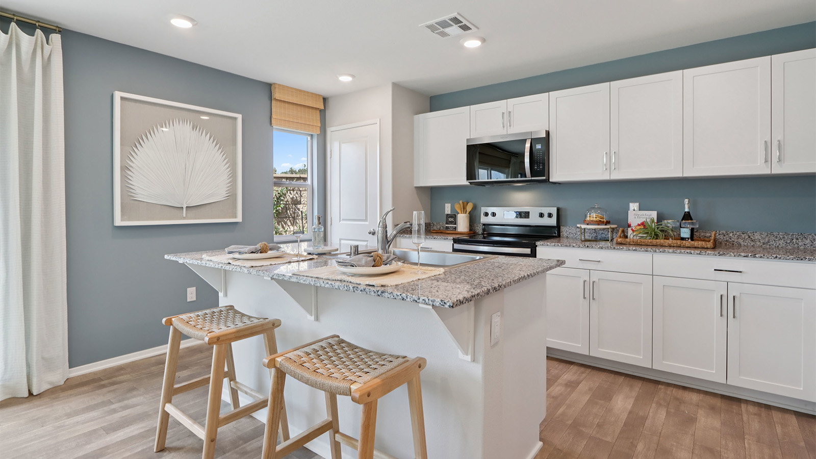Kitchen with white cabinets and granite countertops with an island
