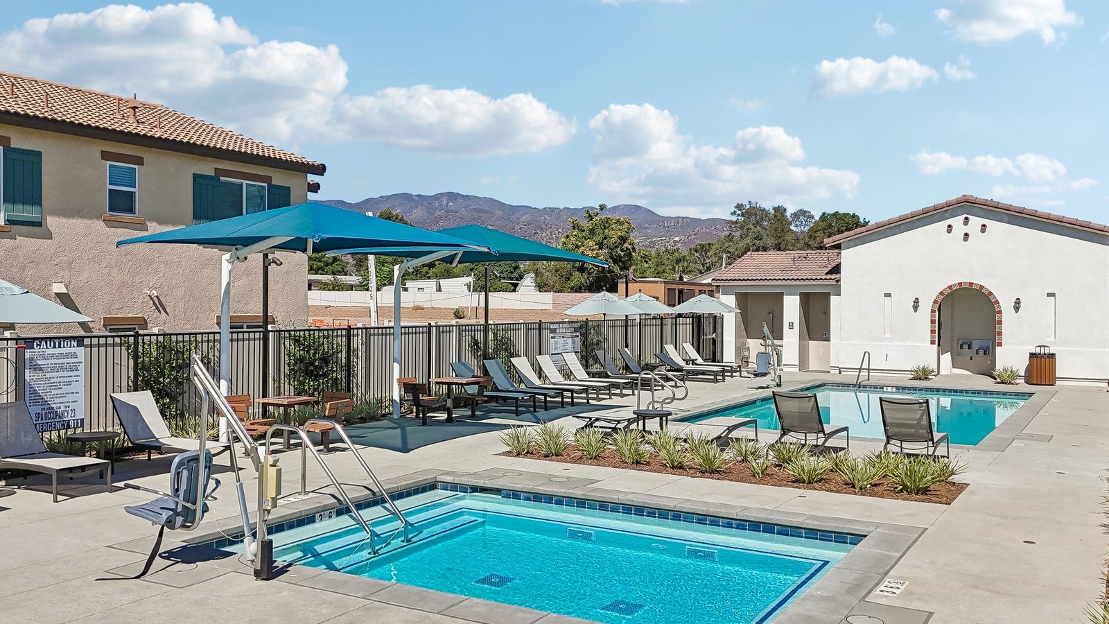 Community Pool with lounge chairs and restroom building