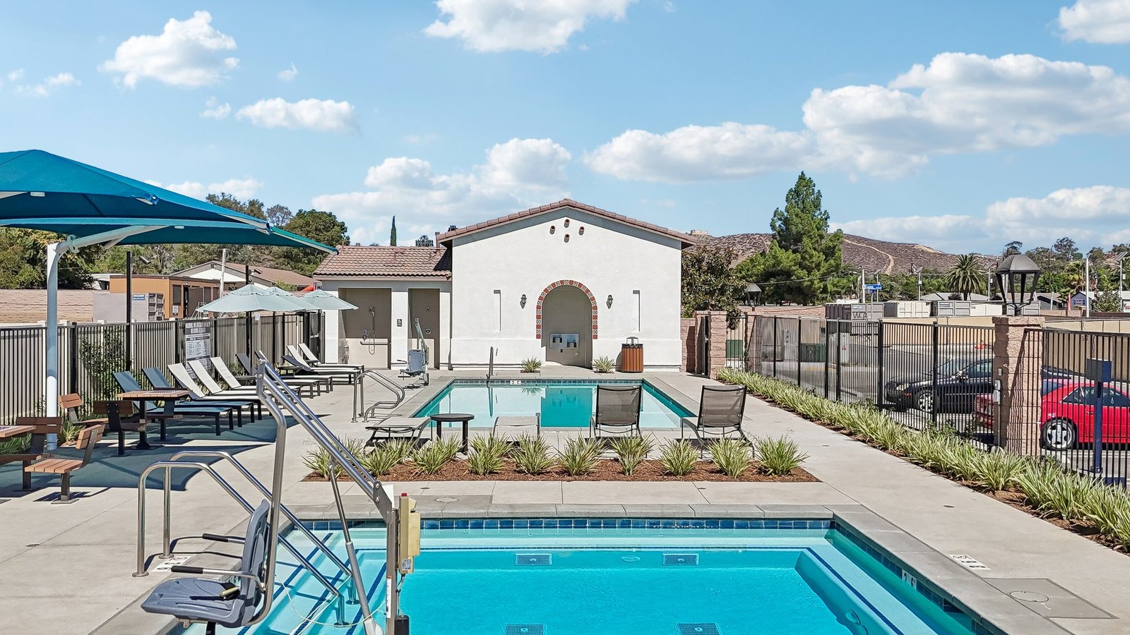 Community Pool with lounge chairs and restroom building
