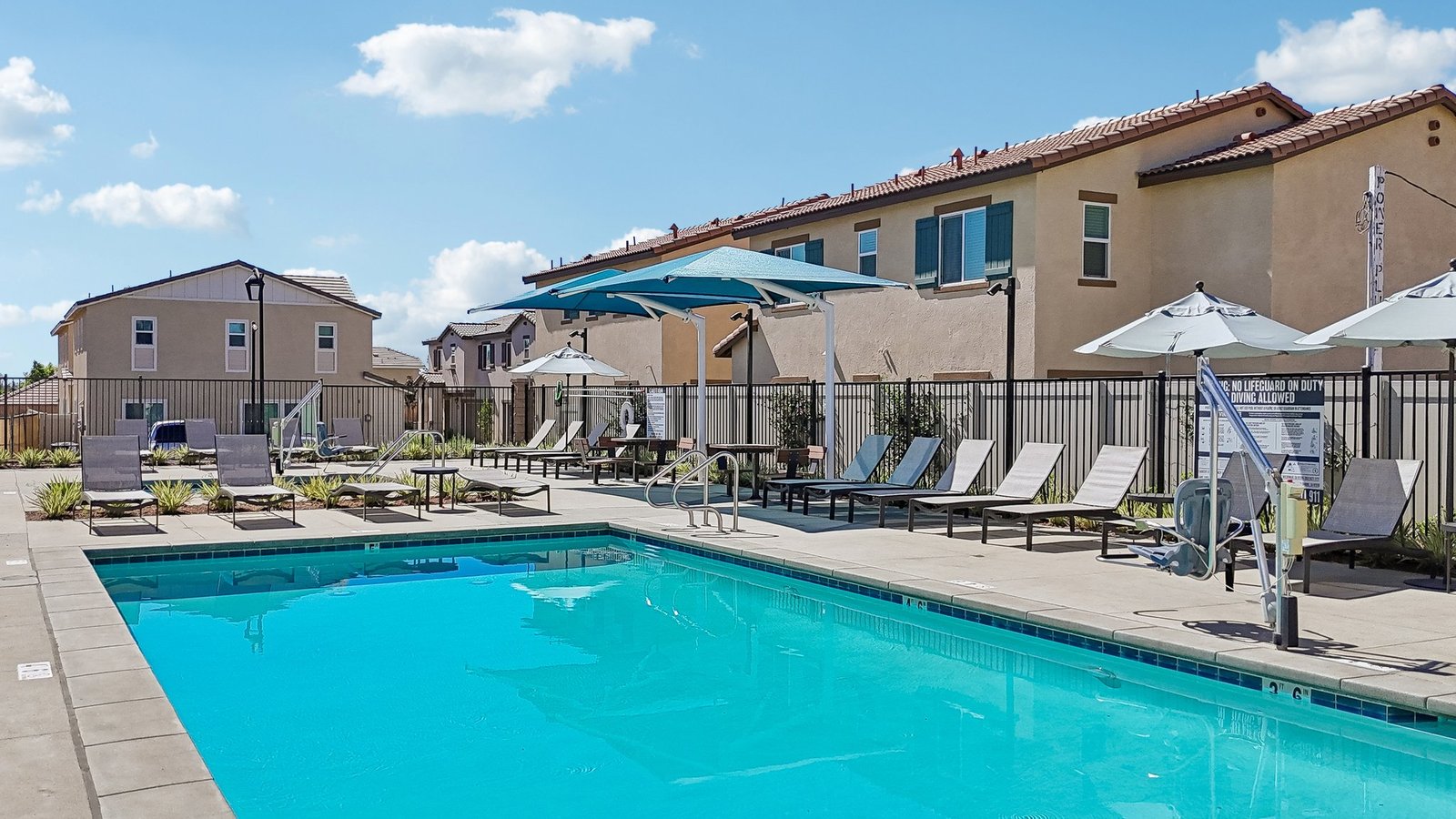 Community Pool with lounge chairs and restroom building