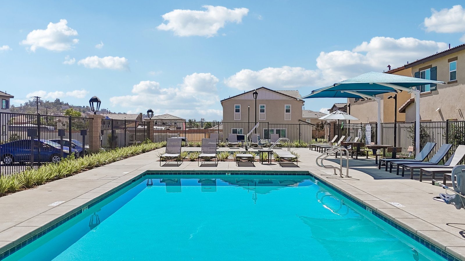 Community Pool with lounge chairs and restroom building