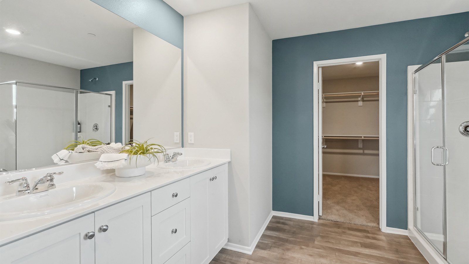 Primary bathroom with double sinks and a walk-in closet