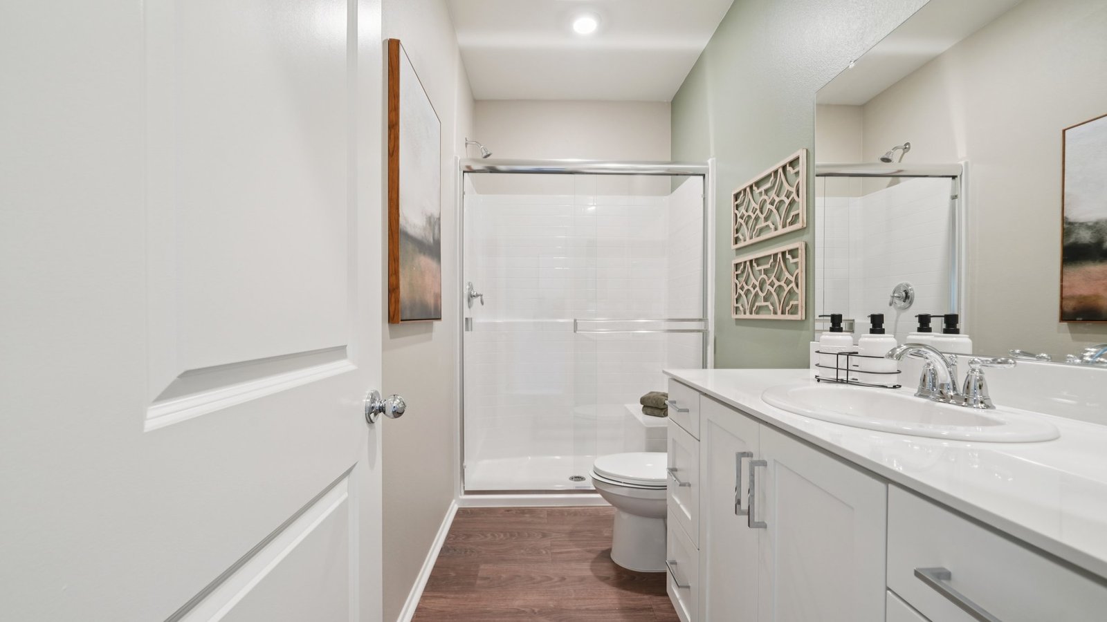 Secondary bathroom with white cabinets and shower
