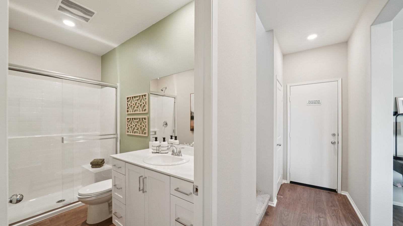 Secondary bathroom with white cabinets and shower