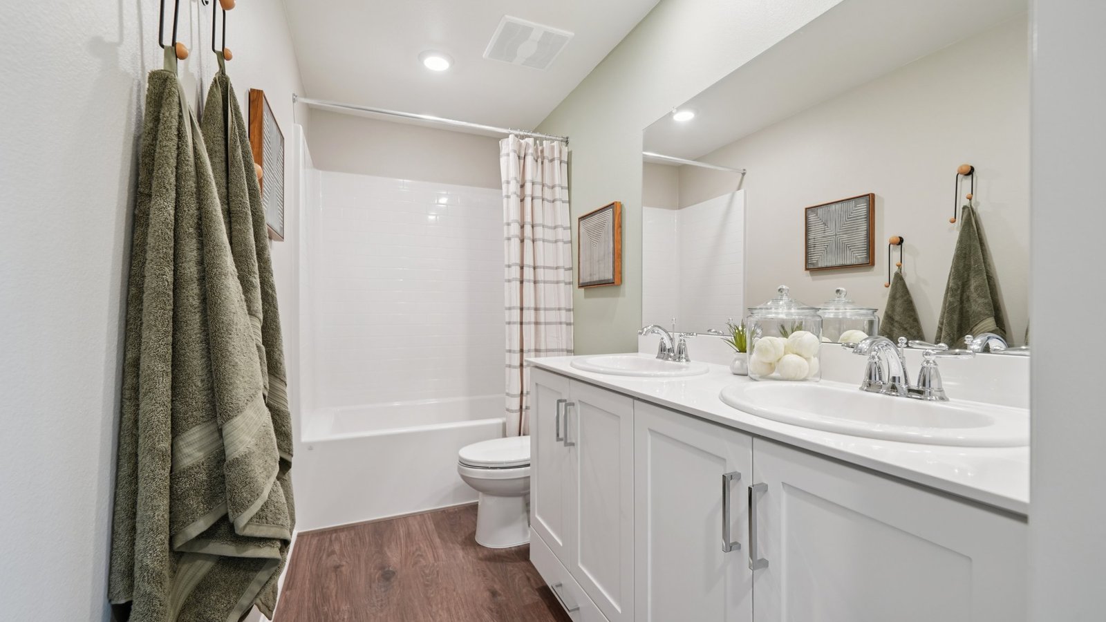 Secondary bathroom with white cabinets and tub shower