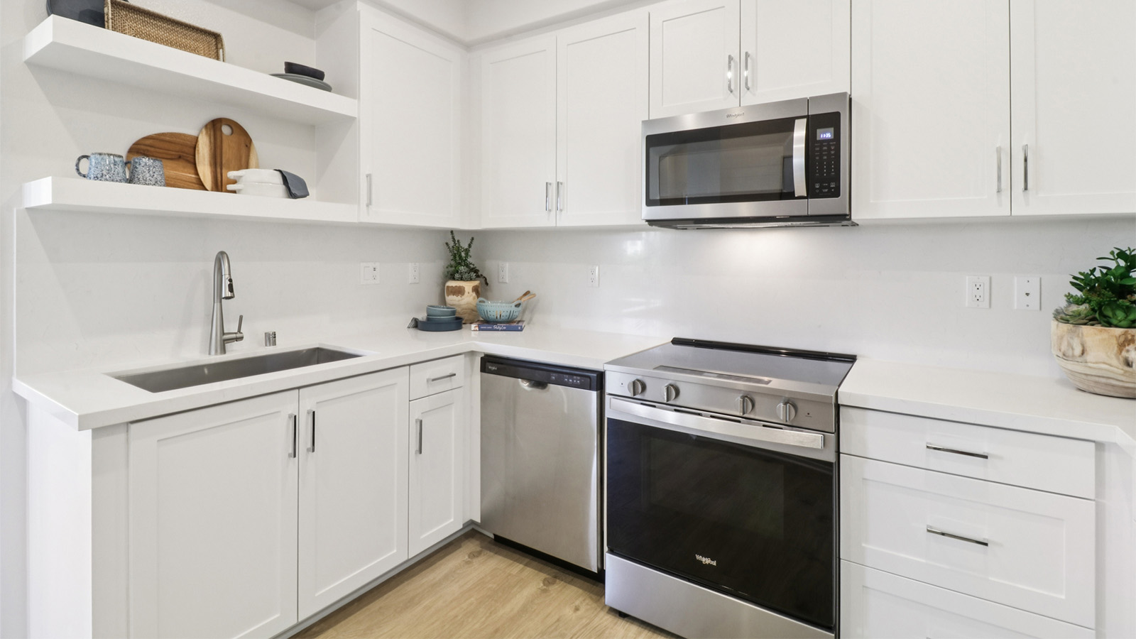 Kitchen with single-basin sink, white cabinets, and stainless-steel appliances