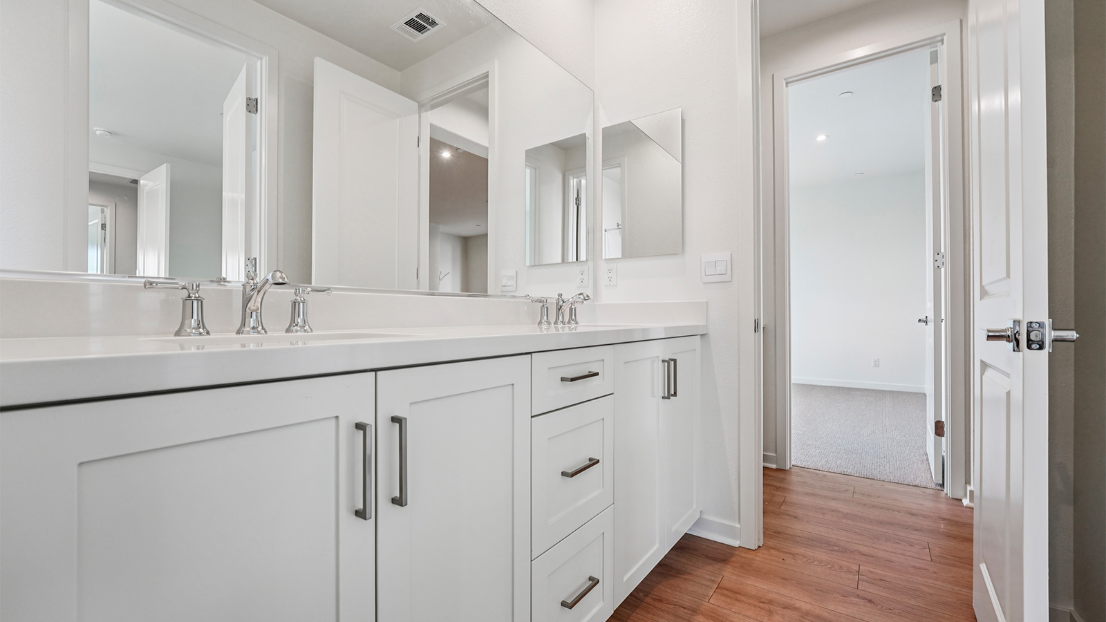 Secondary bathroom with white cabinets and double sinks