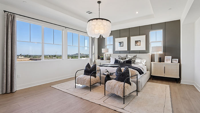 Interior primary bedroom with accent wall and large windows