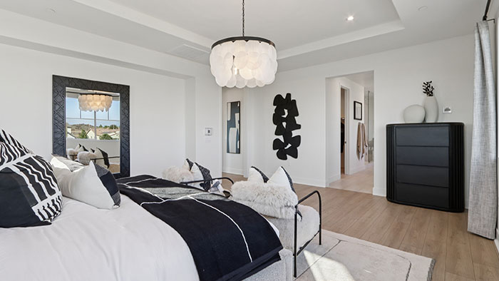 Interior primary bedroom with accent wall and large windows
