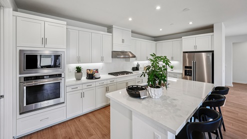 Spacious kitchen with white cabinets, stainless-steel appliances, and a large island