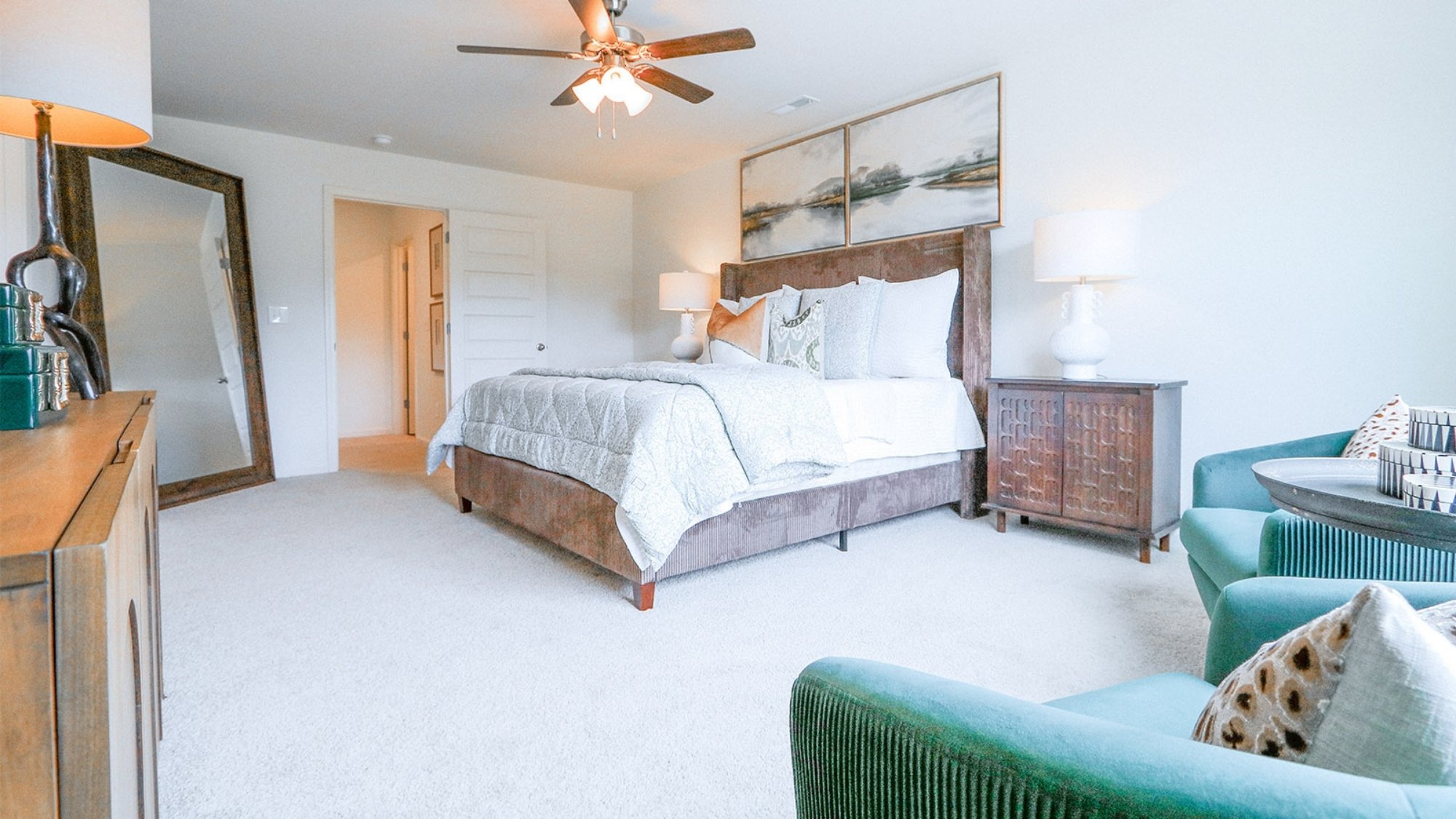 The primary bedroom has enough space for a king sized bed, two nighstands, a dresser, and a seating area.
