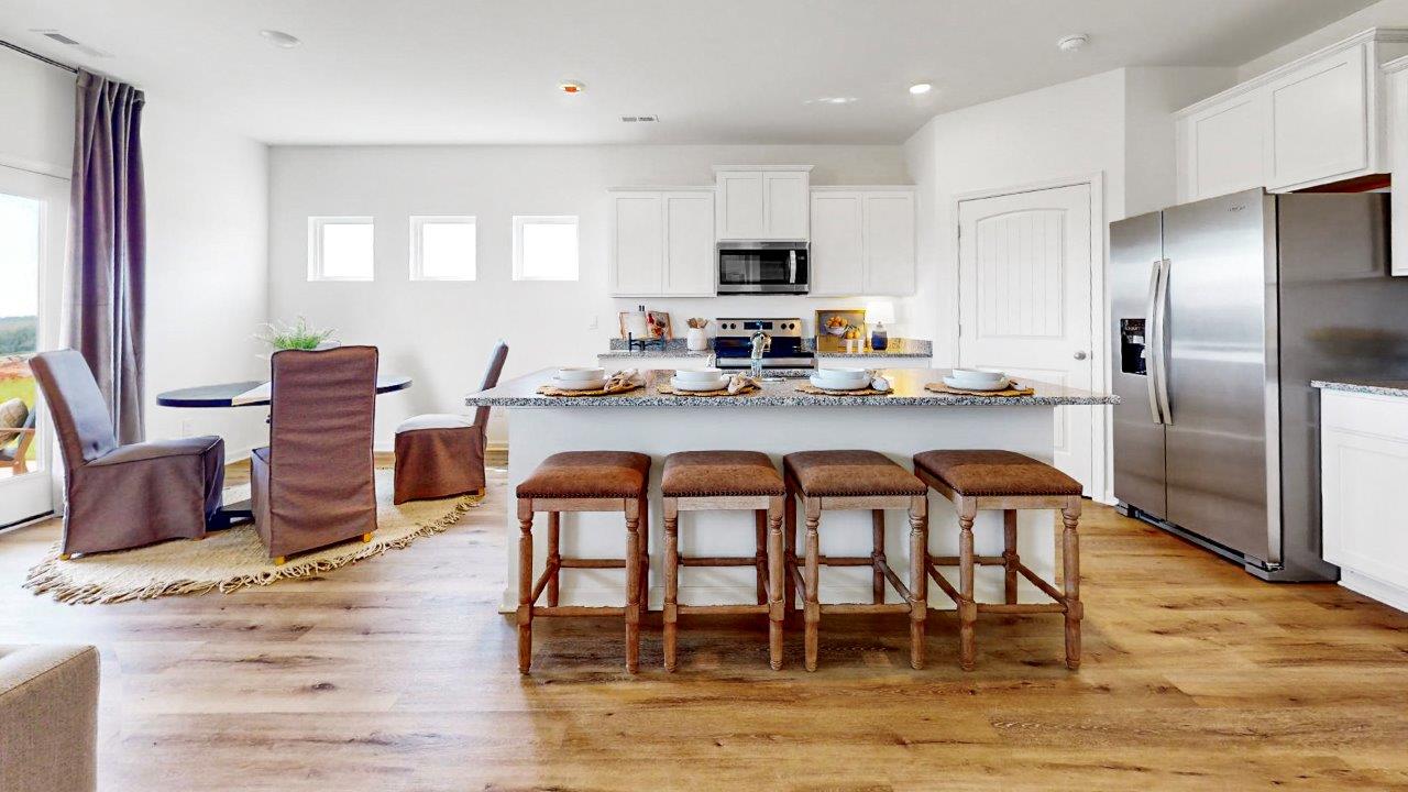 Another view of the kitchen that shows off the island with barstools and the breakfast area.