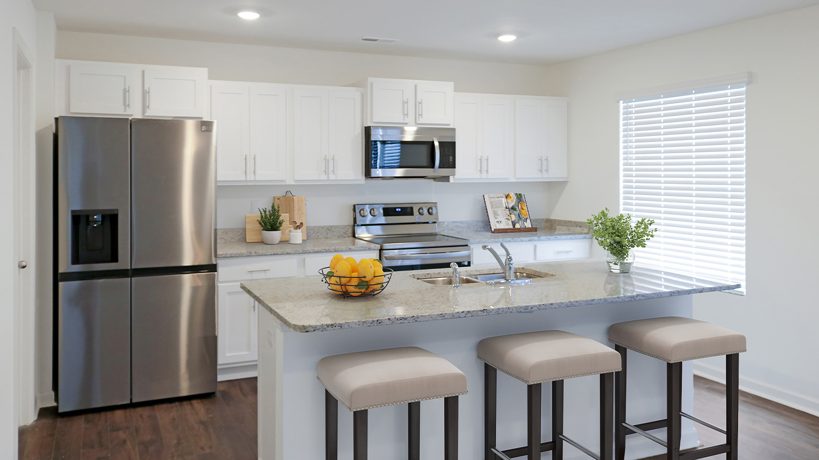 The kitchen is outfitted with modern stainless steel appliances, a roomy pantry, and an eat-in island with room for 3 barstools.