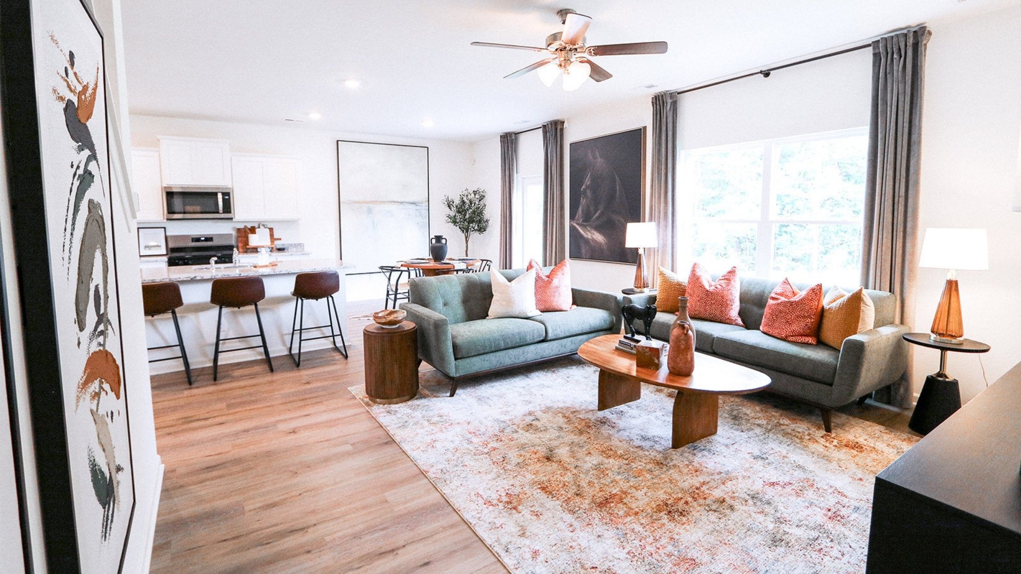 Shown here, it is staged with a large couch, a love seat, a large coffee table, two sides tables, and a large television.