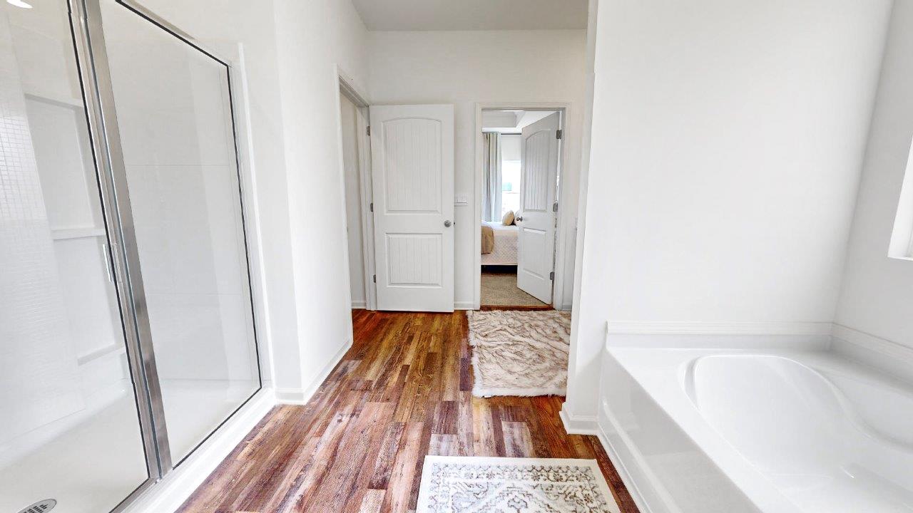 The primary bathroom features a spacious walk-in shower. Additionally, it includes a large soaking garden tub for relaxation. There is also a water closet for added privacy.