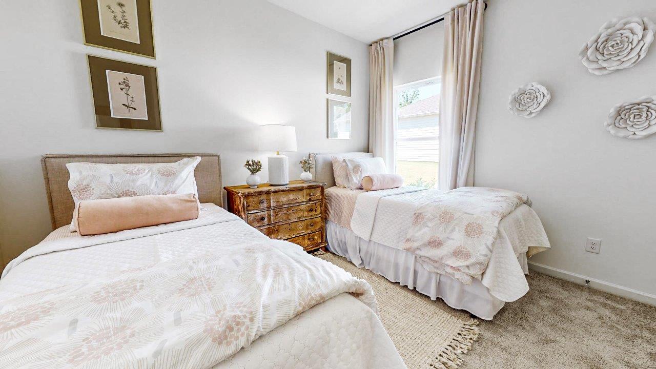 The alternate view of the second bedroom displays the bed and the double doors of the closet.