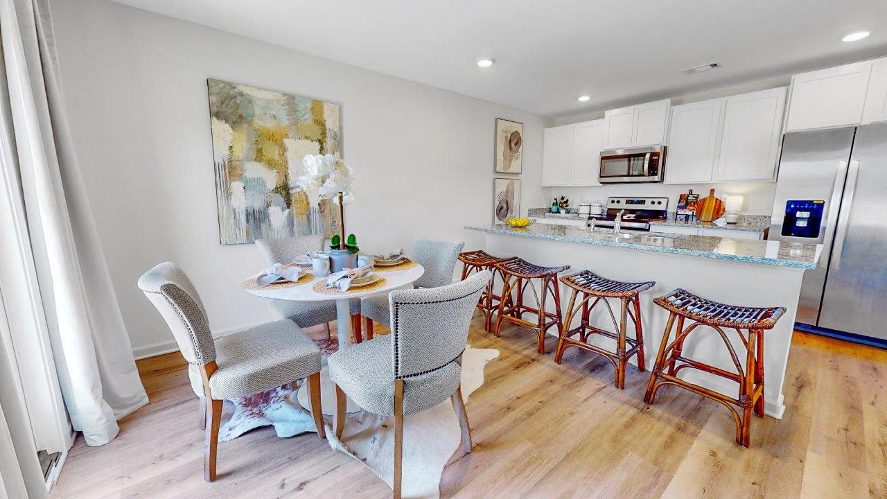 Open-concept kitchen with a large island, stainless steel appliances, and a pantry tucked nearby for convenience.