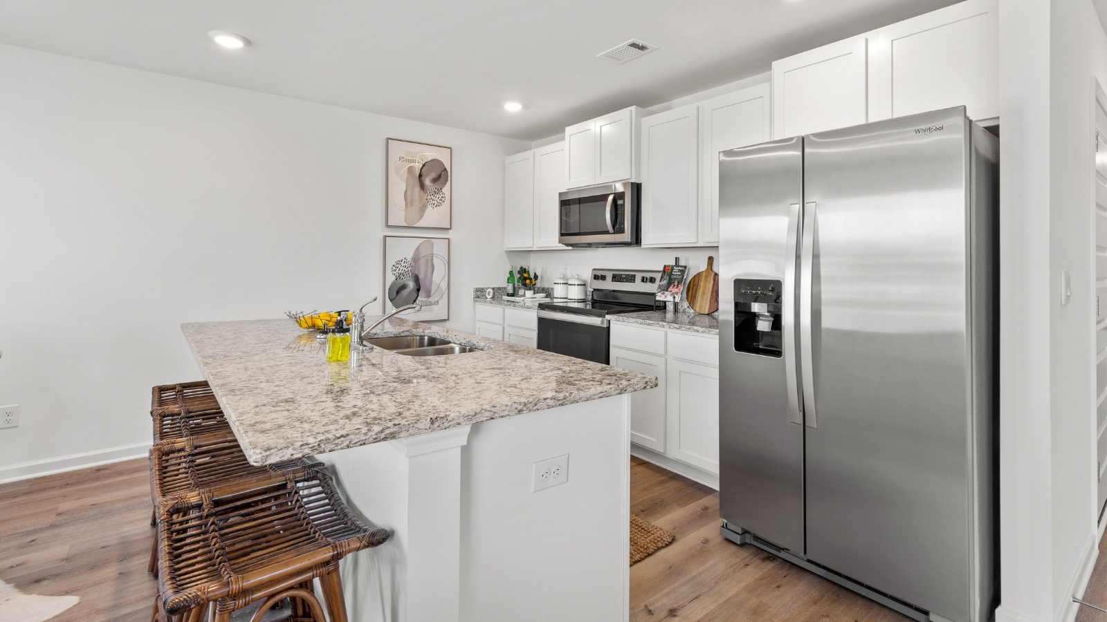 Modern kitchen featuring a spacious island with a stainless steel sink, perfect for meal prep and adding functionality to the open layout.