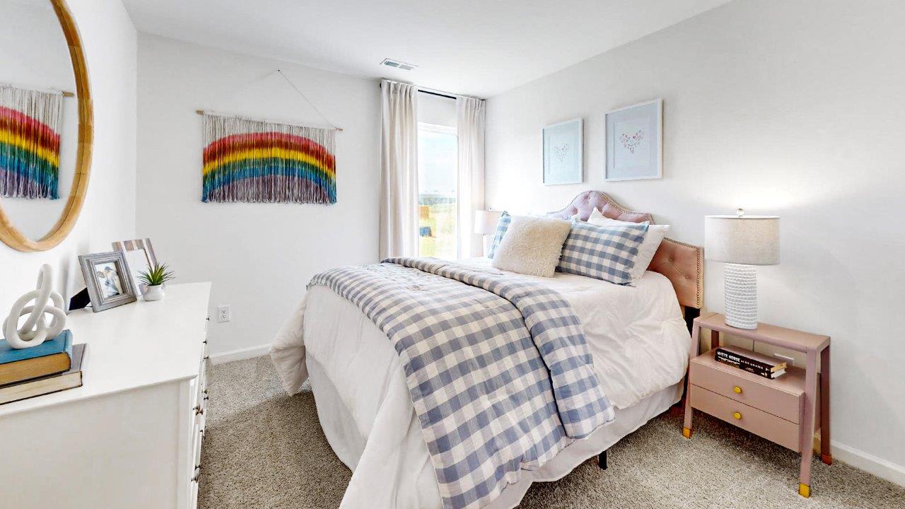 Guest bedroom with a colorful rainbow decorates a bedroom with a bed, 2 nightstands and a dresser