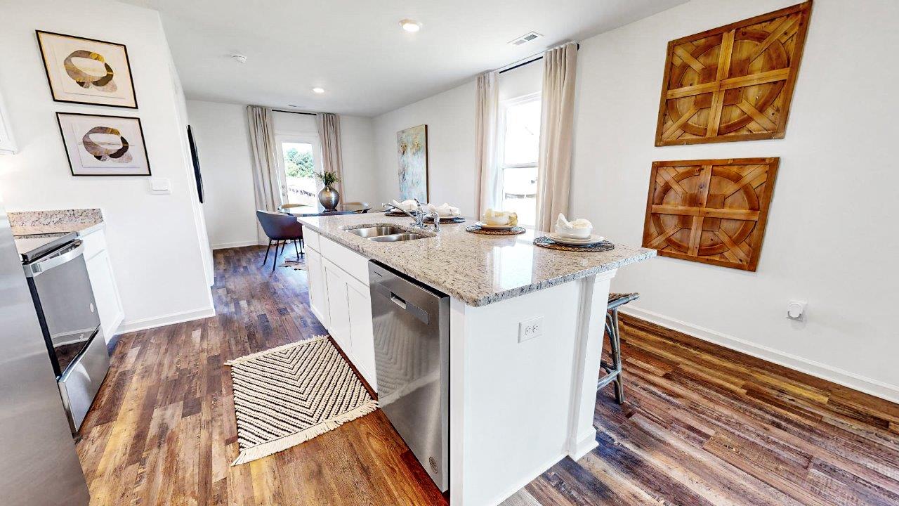 Kitchen with stainless steel appliances, an island, and wooden floors.