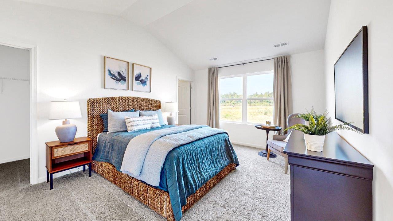 Primary bedroom with a comfortable bed, stylish dresser, 2 nightstands, tv and a double window.