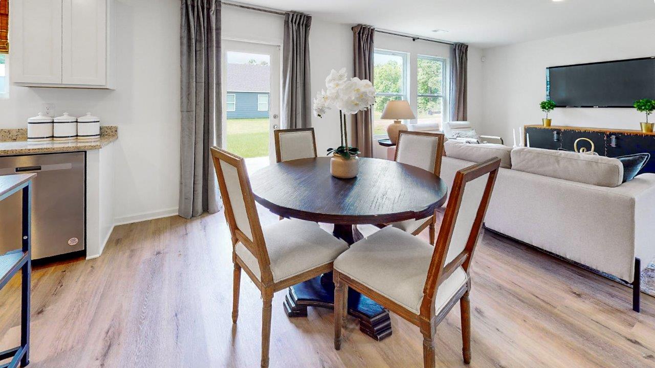 Dining area features a round table with 4 chairs, and a door to the outdoor patio.
