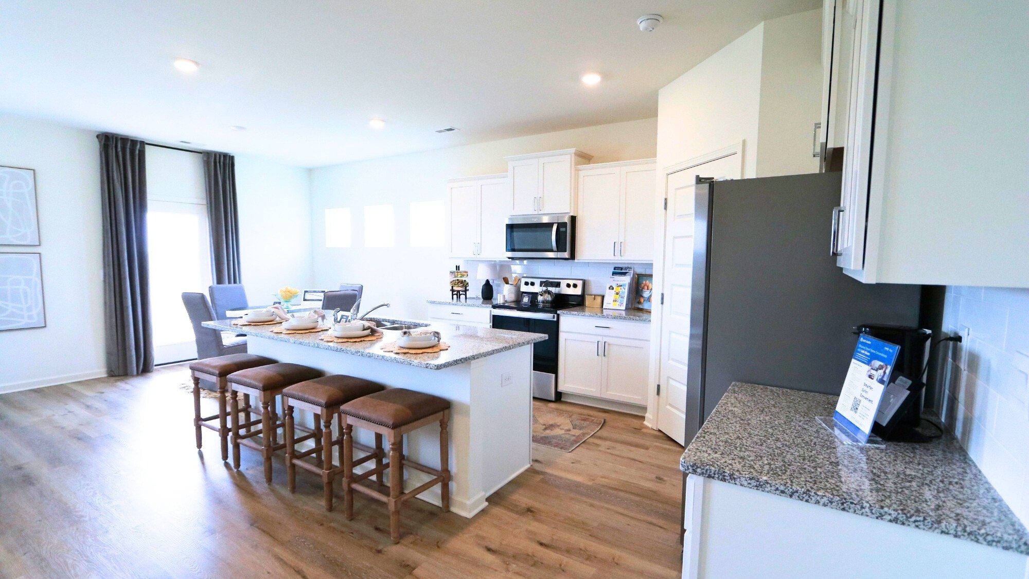 The kitchen is outfitted with modern stainless steel appliances, a roomy pantry, and an eat-in island with room for 3-4 barstools.