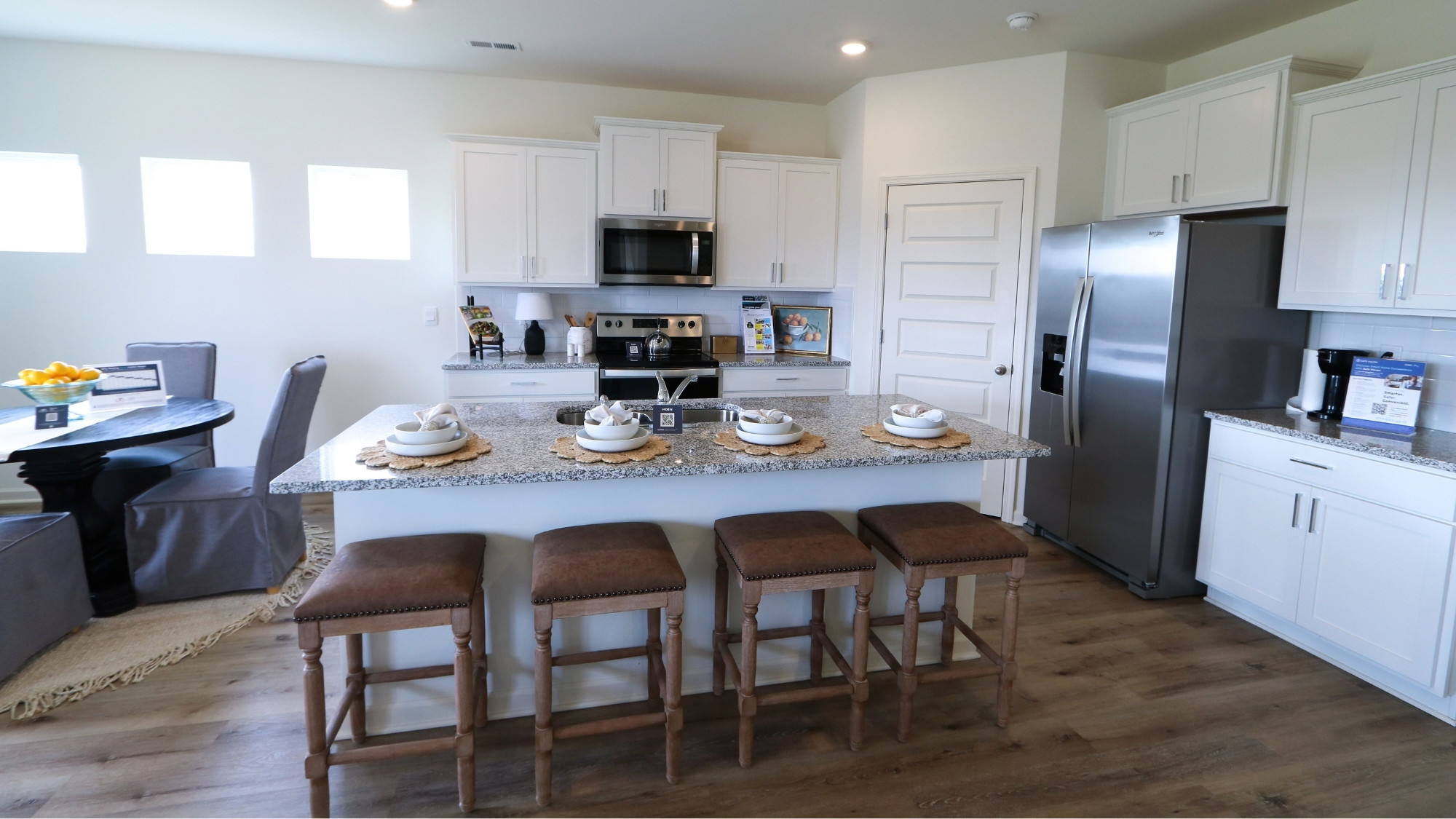 The living room has ample space for a full suite of living room furniture. It features large windows, which allow for ample natural light to flood the space.
