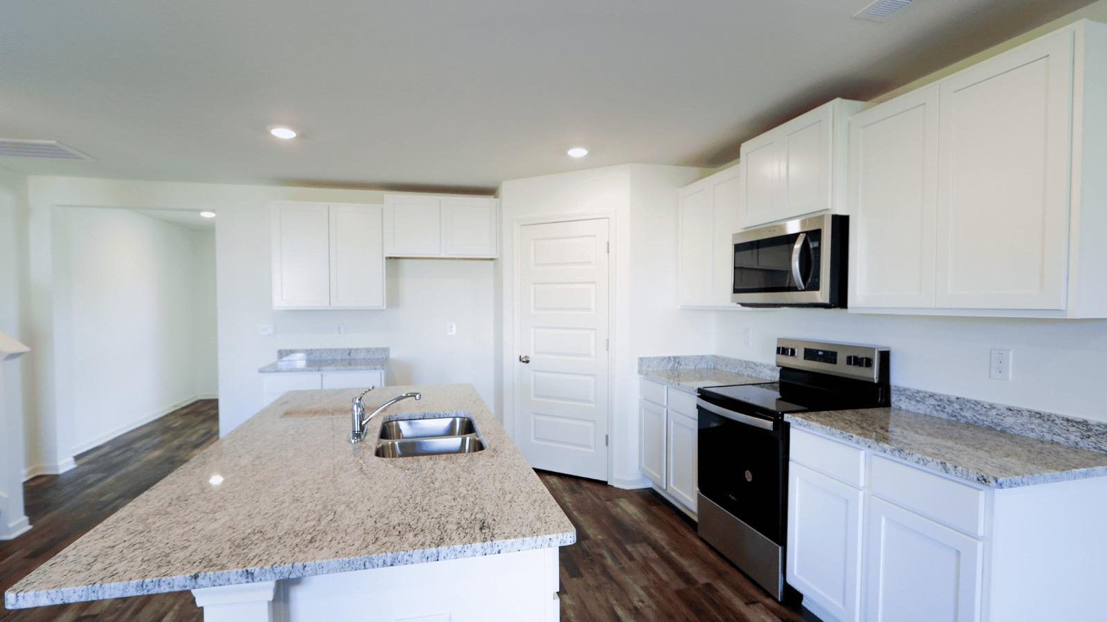 Modern kitchen features white cabinets, granite countertops, stainless steel appliances, and hardwood flooring.