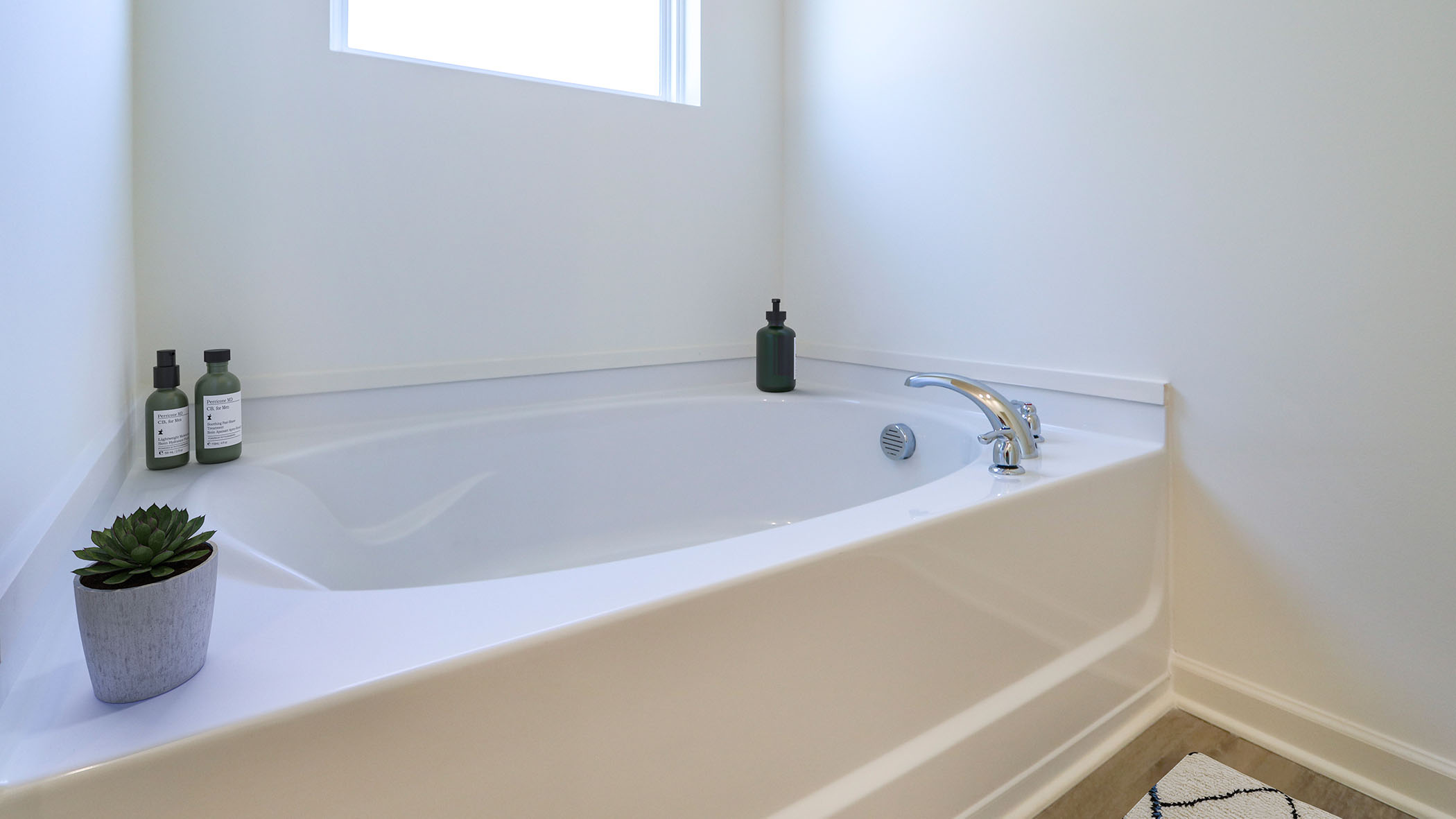 The garden tub has a window above it.