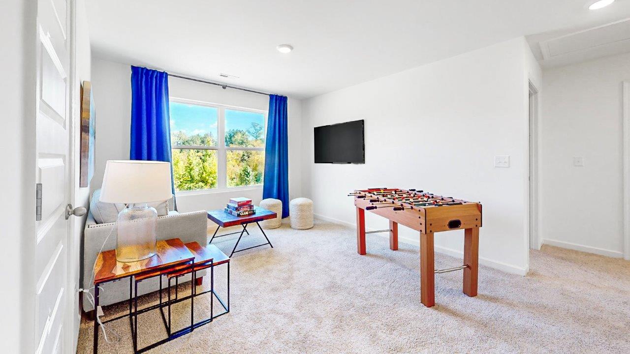 the loft style bonus room is great for entertaining or a play area for children with a couch and media consol