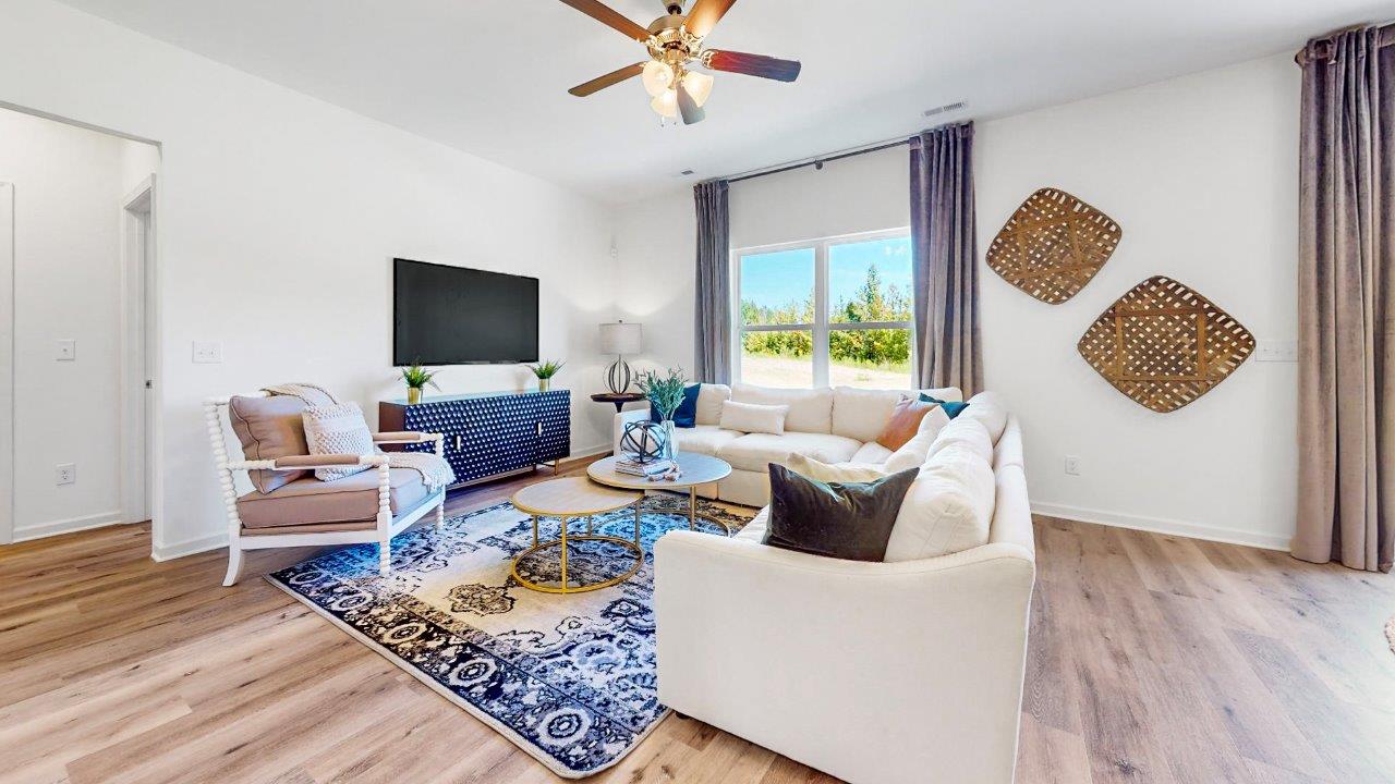 A large sectional couch, 2 chairs and and media consol complete the large spacious living room