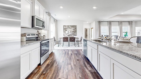 Destin – Kitchen – 1 – the open concept kitchen features a large island, white cabinets, stainless steel appliances and opens the full breakfast nook