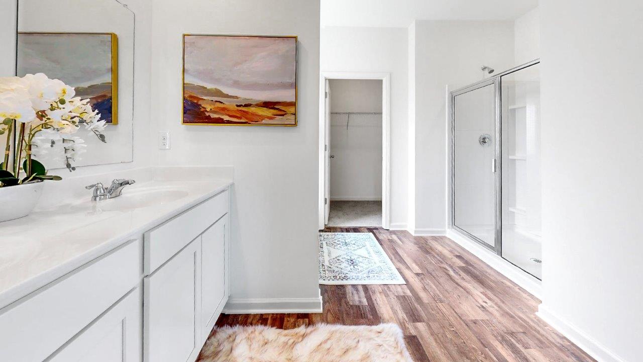 Primary bathroom which is right off of the primary bedroom features a double vanity with 2 sinks, a walk in shower and the primary closet in the back