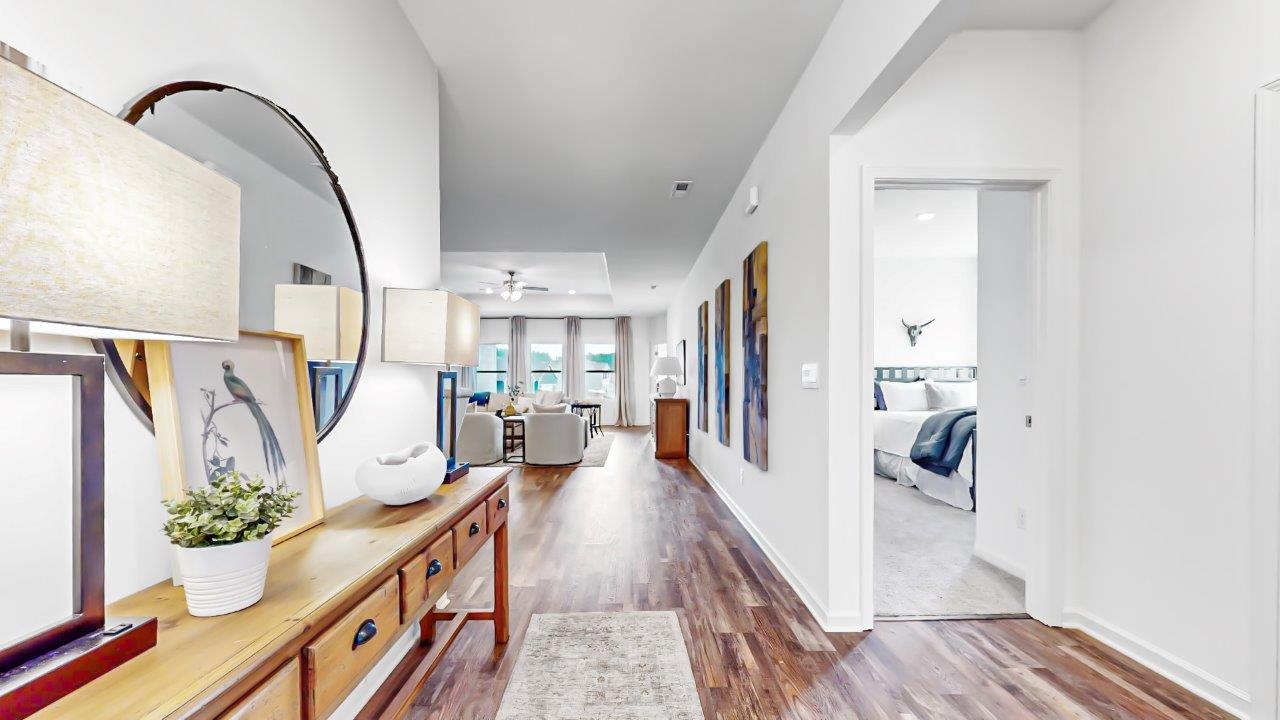 Foyer to the destin plan shows a sofa table on the left with 2 lamps and then on the right in are the doorways to the second and third bedrooms as well as the shared full bathroom