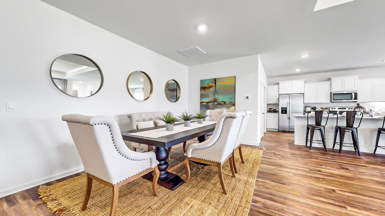Formal dining area features a full-sized dining table with 4 chairs and a bench seat and opens to the kitchen