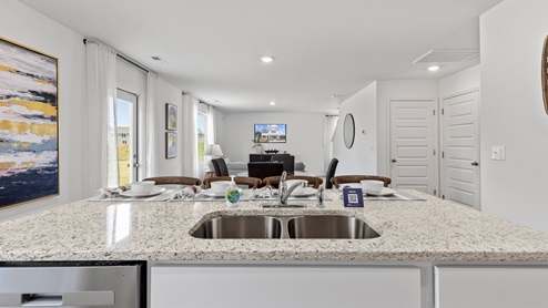 Penwell – Kitchen – 1 - A well-lit kitchen with a wooden dining table and chairs, creating a cozy and inviting atmosphere.