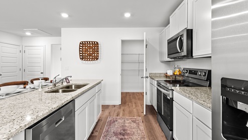 Penwell – Kitchen – 1 - A well-lit kitchen with a wooden dining table and chairs, creating a cozy and inviting atmosphere.