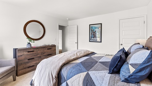 Penwell – Bedroom 2 – Spacious second bedroom with a bed, 2 nightstands, and chair and a dresser