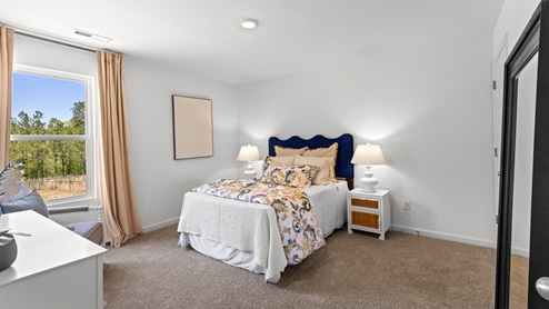 Penwell – Bedroom 2 – Spacious second bedroom with a bed, 2 nightstands, and chair and a dresser