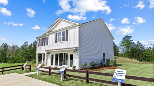 Beautiful exterior of the penwell model home in saddlewood trails, with white siding, lush green grass and a serene blue sky