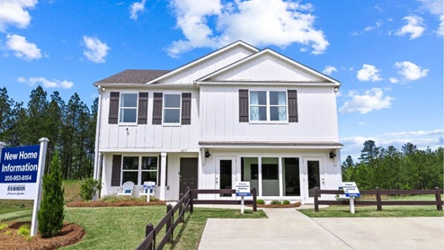 Beautiful exterior of the penwell model home in saddlewood trails, with white siding, lush green grass and a serene blue sky