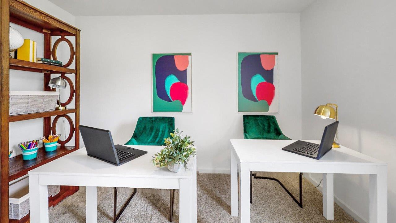 Home office with two computers and a bookshelf providing a productive workspace for work or study