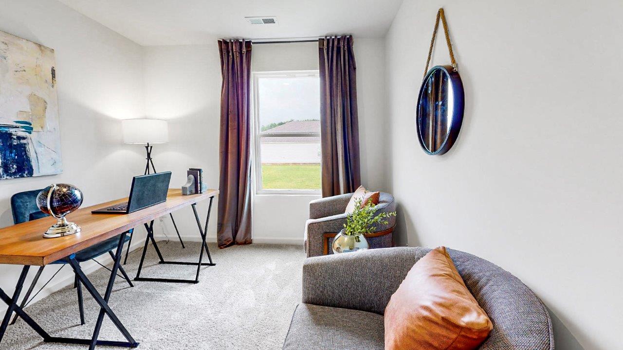 Bedroom is currently used as an office with a large desk and two sitting chairs