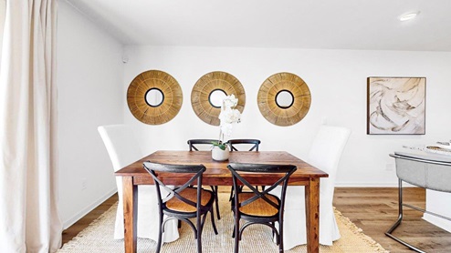 The dining area features a spacious kitchen table and six chairs, connecting seamlessly to the kitchen.
