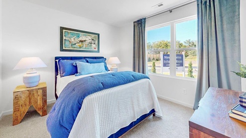 This bedroom is currently being used as an office, featuring a spacious desk and two comfortable sitting chairs.