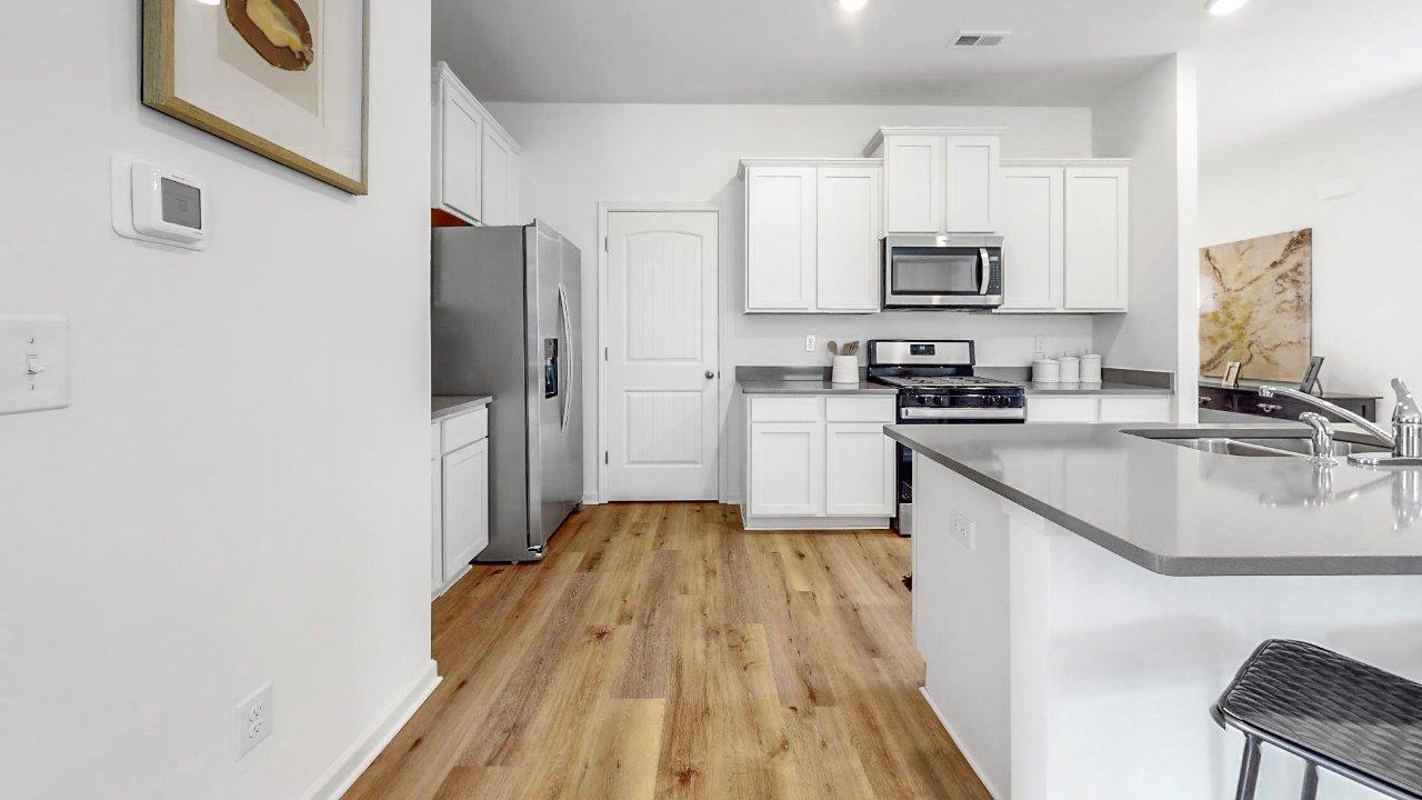 Another view of the kitchen that shows the stainless steel appliances, and the kitchen island