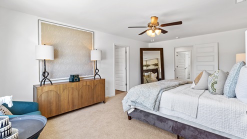 The primary bedroom has enough space for a king sized bed, two nighstands, a dresser, and a seating area.