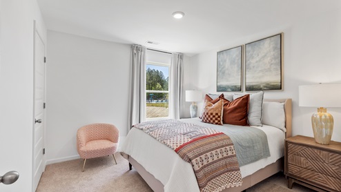 The primary bedroom has enough space for a king sized bed, two nighstands, a dresser, and a seating area.